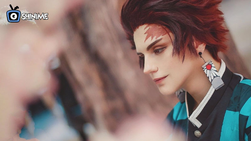 Cosplay de Tanjiro con kimono a cuadros y aretes hanafuda, personaje top para cosplay en 2025.