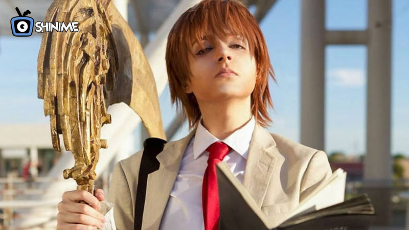 Cosplayer de Light con traje beige y libreta Death Note, personaje icónico entre popular anime cosplays.