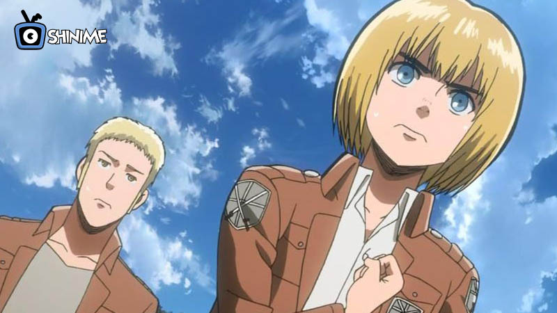 Armin Arlert clenching his fist with Reiner beside him, showcasing strategic brilliance in Attack on Titan