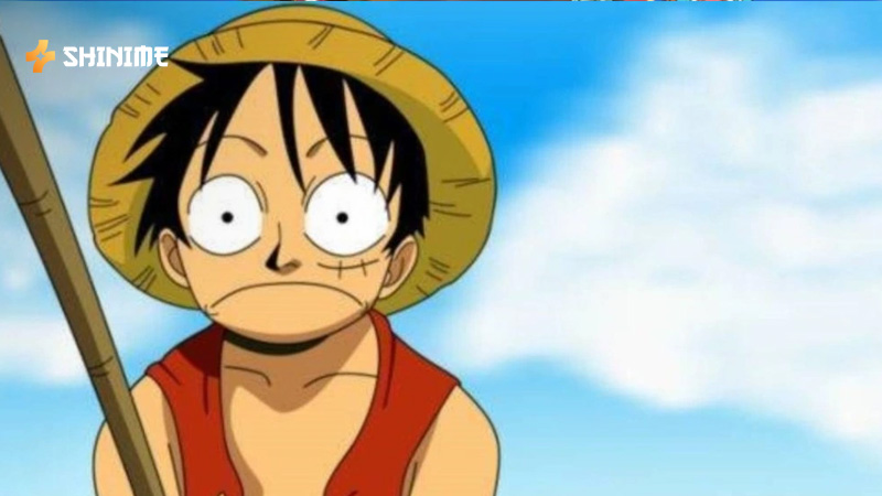Luffy with raised fist and straw hat, showing resolve in One Piece Movie 1 scene